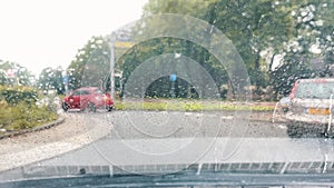 Selective focus. Raindrops on the windshield. Traffic cars in the city in bad weather conditions