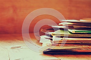 Selective focus of records stack with record on top over wooden table. vintage filtered