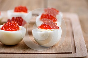 Selective focus. Red caviar on halves of hard-boiled chicken egg