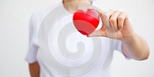 Selective focus of red heart held by female nurse`s hand, representing giving all effort to deliver high quality service mind