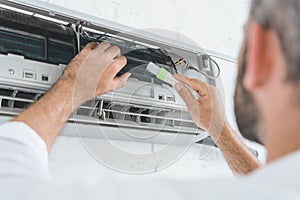 selective focus of repairman cleaning air conditioner