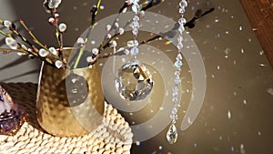 Selective focus on round ball shape crystal rainbow maker suncatcher hanging in home with Orgonite or Orgone pyramid.