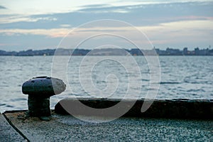 Selective focus of rusted steel post for seizing the ship at the pier photo