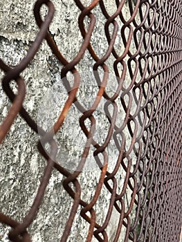 Selective Focus on Rusty Metal grid in front of Cement Wall