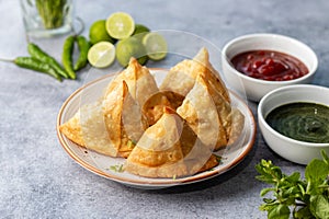 selective focus Samosa, Spiced potato-filled pastry, crispy, Savory, popular Indian snack with tomato and mint chutney.