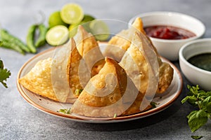 selective focus Samosa, Spiced potato-filled pastry, crispy, Savory, popular Indian snack with tomato and mint chutney.