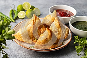 selective focus Samosa, Spiced potato-filled pastry, crispy, Savory, popular Indian snack with tomato and mint chutney.