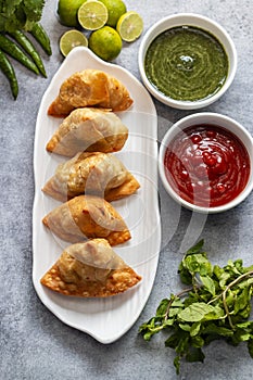 selective focus Samosa, Spiced potato-filled pastry, crispy, Savory, popular Indian snack with tomato and mint chutney.