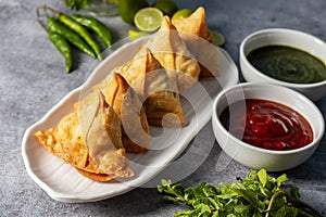 selective focus Samosa, Spiced potato-filled pastry, crispy, Savory, popular Indian snack with tomato and mint chutney.