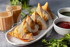 selective focus Samosa, Spiced potato-filled pastry, crispy, Savory, popular Indian snack with tomato and mint chutney.