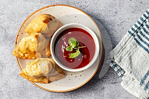 selective focus Samosa, Spiced potato-filled pastry, crispy, Savory, popular Indian snack with tomato and mint chutney.