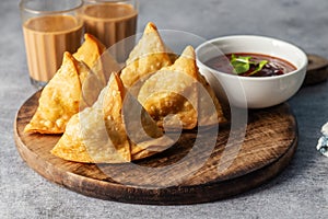 selective focus Samosa, Spiced potato-filled pastry, crispy, Savory, popular Indian snack with tomato and mint chutney.