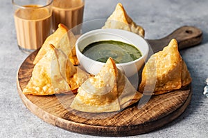 selective focus Samosa, Spiced potato-filled pastry, crispy, Savory, popular Indian snack with tomato and mint chutney.