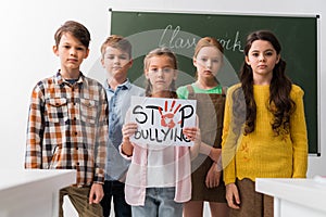 Selective focus of schoolkids holding placard