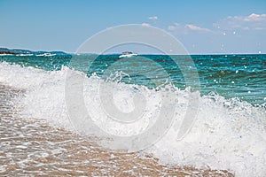 Selective focus on the seascape with splahs and the foaming waves.