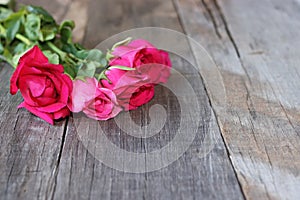 Selective focus and shallow depth of field of bouquet of beautiful red roses on old wooden background. Valentine`s Day concept