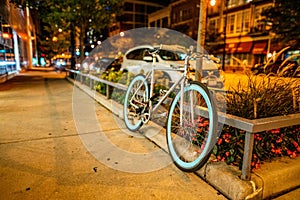Selective focus shot of a bicycle parked on the sidewalk during evening time