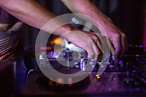 Selective focus shot of black DJ controller with hands of DJ
