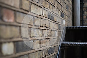 Selective focus shot of a brick wall with a stai photo