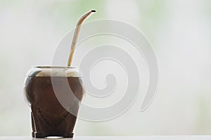 Selective focus shot of a  calabash mate cup with straw - yerba mate tea infusion