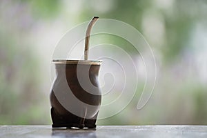 Selective focus shot of a  calabash mate cup with straw - yerba mate tea infusion