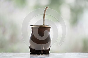 Selective focus shot of a  calabash mate cup with straw - yerba mate tea infusion