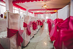 Selective focus shot of chairs and tables with a decorative ribbon style in a wedding reception