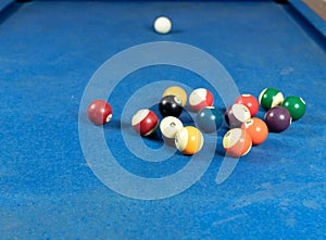 Selective focus shot of colorful billiard balls on pool blue table