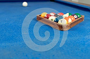 Selective focus shot of colorful billiard balls on pool blue table