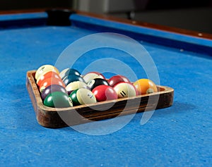 Selective focus shot of colorful billiard balls on pool blue table