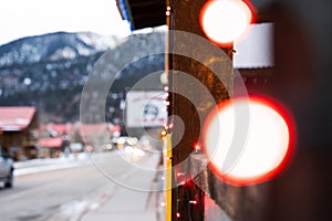 Selective focus shot of the colorful Christmas lights hanging on the wooden house wall