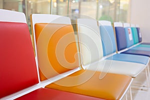 Selective focus shot with copy space of many colorful chairs in a row in the lobby or waiting room in hospital shows joyful,