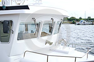 Selective focus shot of the deck and windows of a modern, white boat