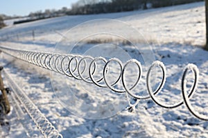 Selective focus shot of the electric fence covered with frost
