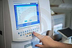 Selective focus shot of a female doctor adjusting the CBC (complete blood count) blood test machine