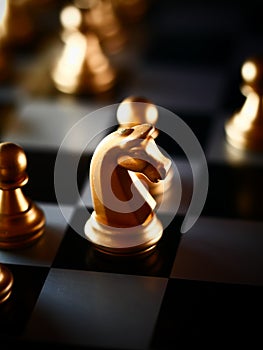 Selective focus shot of golden knight and pawn chess pieces on a chessboard