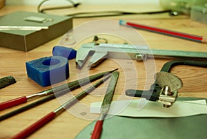 Selective focus shot of graphing tools on a table: tensioner, caliper, files, sponges, pencil