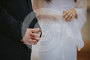 Selective focus shot of groom and bride hands during the wedding ceremony