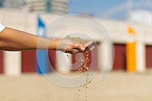 Selective focus shot of hands holding loose sand, Barceloneta Beach, Barcelona, Spain