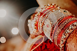 Selective focus shot of an Indian bride with lots of beautiful bracelets