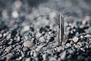Selective focus shot of a key half burried in pebbles