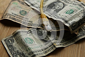 Selective focus shot of a LAN cable on one-dollar bills