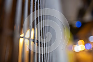 Selective focus shot of metal bars with blurred lights in the background