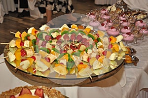 Selective focus shot of a platter of fruit skewers on a dessert buffet table