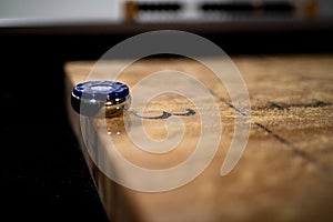 Selective focus shot of a puck on the edge of the table shuffleboard