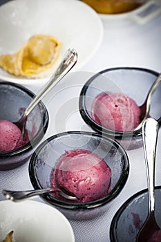 Selective focus shot of raspberry sorbet in small bowls on a white table