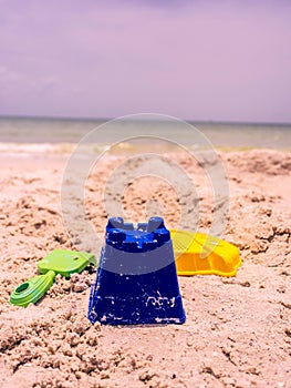 Selective focus shot of sand toys on a beach in Florida