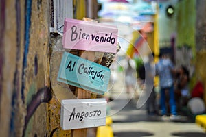 Selective focus shot of a sign in Spanish which says 'Bienvenido Al Callejon Angosto'