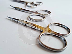 Selective focus shot of three manicure scissors isolated on a white background