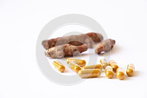 Selective focus shot of turmeric herb capsule on isolate white background. Alternative, natural healthcare product instead of